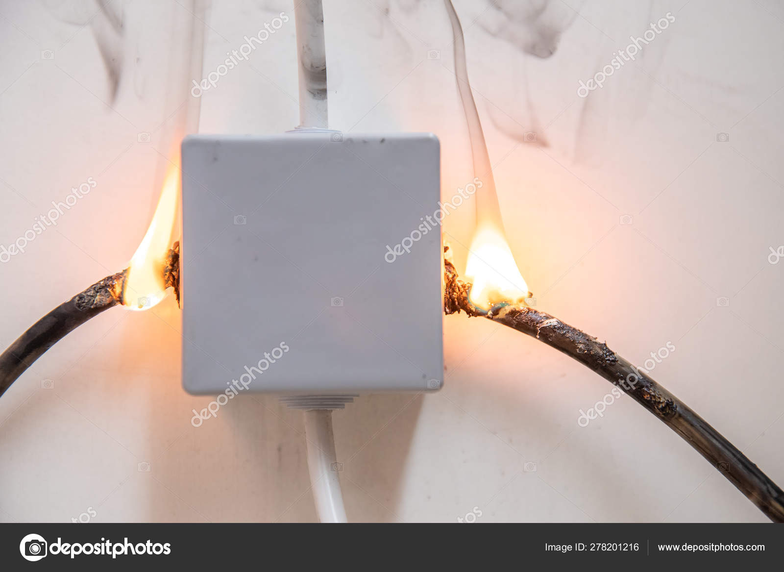 Electrical short circuit. Wiring cable on fire flame Stock Photo by