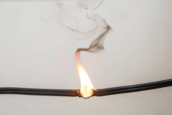 Electrical short circuit. Wiring cable on fire flame — Stock Photo, Image