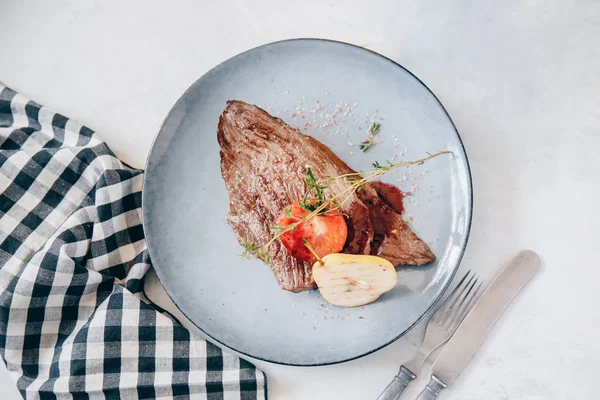 Vue de dessus steak de viande fraîche grillée avec décoration poire et tomate. Fond clair — Photo