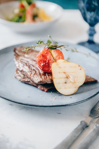 Steak de viande fraîche avec décoration poire et tomate. Couverts et verre à vin. Concept restaurant — Photo