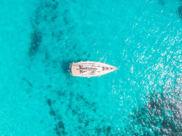 Vista aérea yate blanco con vela se encuentra en el arrecife de coral en azul transparente mar turquesa. Concepto de viaje — Foto de Stock