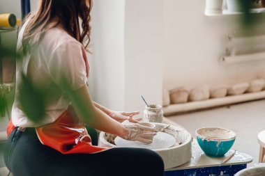 İş çömlekçi tekerleği. Kilden kırmızı önlük heykel mutlu genç kadın