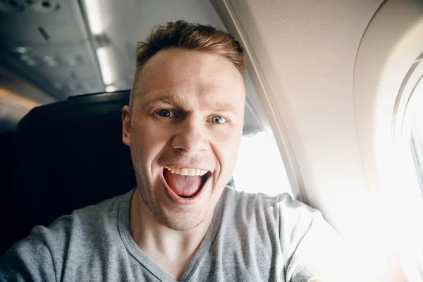 Man ler och tar Selfie foto på plan flygplan. Resekoncept — Stockfoto