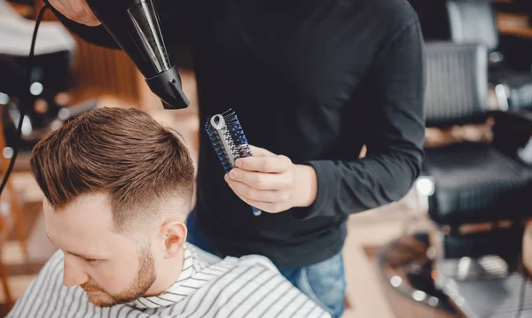 Close-up Master Barber doet kapsel en styling met droger haar naar Guy. Concept Barbershop — Stockfoto
