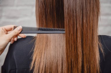 Ana salonda dişleriyle saç tarak. Güzel ve sağlıklı