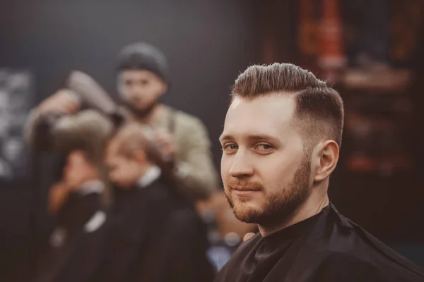 Barbearia. Homem com barba na barbearia. Salão de cabeleireiro moderno — Fotografia de Stock