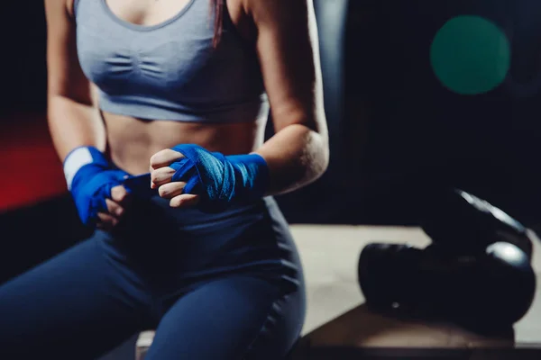 Молодая сильная независимая женщина кулаками бинты для тренировки в тренажерном зале — стоковое фото