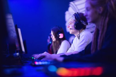 Profesyonel takım oyuncusu turnuva oynuyor çevrimiçi oyun bilgisayarı kulaklıkla, kırmızı ve mavi