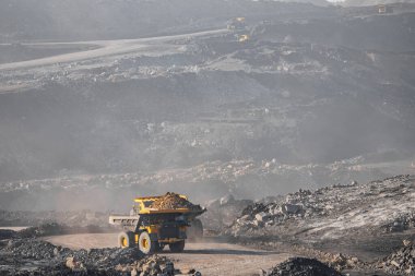 Açık maden endüstrisi. Kömür için büyük sarı maden kamyonu yol kariyerine doğru ilerliyor.