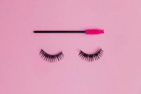 Minimalismo ciglia finte con pennello per pettinare su sfondo rosa. Copia spazio bellezza moda — Foto Stock
