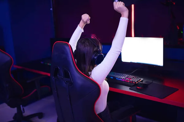 Streamer beautiful girl professional gamer winner rejoices in victory playing online games computer with headphones, back view — Stock Photo, Image