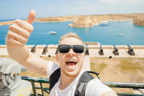 Valletta Malta gelukkig toerist in bril maakt selfie foto op achtergrond panorama gun bay — Stockfoto
