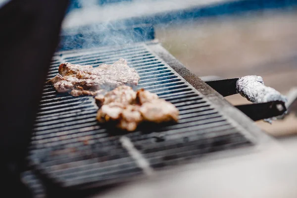 Varkensribbetjes en steak gekookt op grill, open vuur straat voedsel festival — Stockfoto