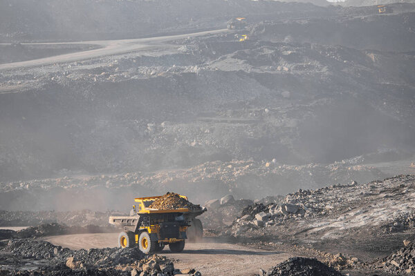 Open pit mine industry. Big yellow mining truck for coal moving on road career