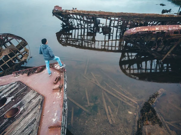 Touristenmann betrachtet den Friedhof alter Holzschiffe in Teriberka, Region Murmansk, Russland. Luftaufnahme von oben — Stockfoto