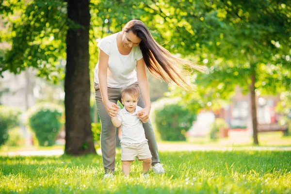Caminhe no parque mãe e filho, primeiro passo, aprenda a ir criança. Família de conceitos — Fotografia de Stock