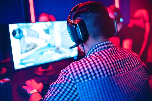 Sala de estudio profesional de cyber gamer con sillón de computadora personal, teclado para flujo en fondo borroso de color neón. Enfoque suave —  Fotos de Stock