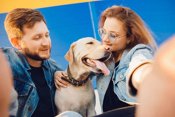 Gelukkig mooi paar is het hebben van plezier met labrador hond retriever buiten het maken van selfie foto — Stockfoto