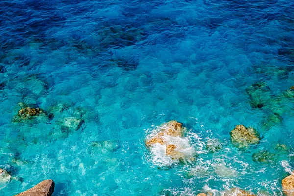 Background turquoise water sea with stones beach, transparent bottom — Stock Photo, Image