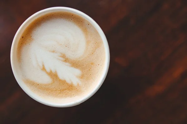 Oberseite Textur aus Schaumstoff und Kaffee-Cappuccino-Latte-Blasen in Pappbecher auf Holztisch, Linsenschlag — Stockfoto