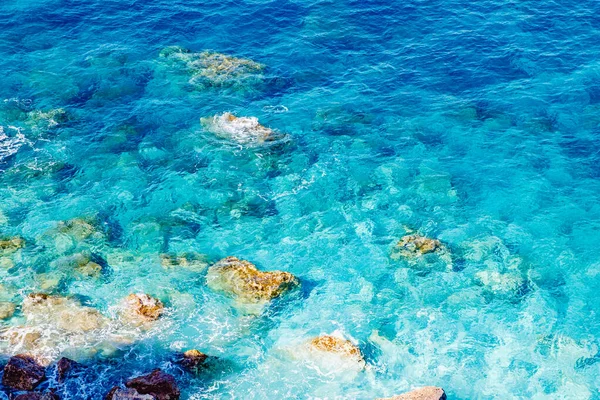Blå smaragd havsvatten med stora stenar stranden. Klippig strand transparent turkos botten Malta — Stockfoto
