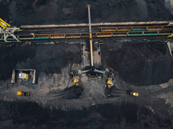Loading coal anthracite mining in port on cargo tanker ship with crane bucket of train. Aerial top view