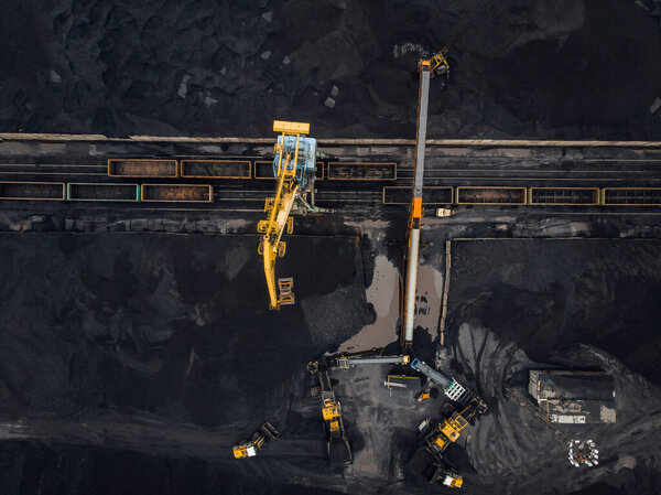 Loading coal anthracite mining in port on cargo tanker ship with crane bucket of train. Aerial top view