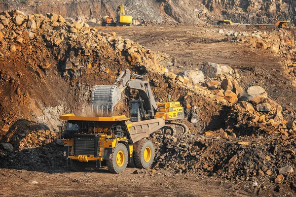 Minería de mineral de oro, cargando cucharón excavadora en el cuerpo del camión de la mina — Foto de Stock