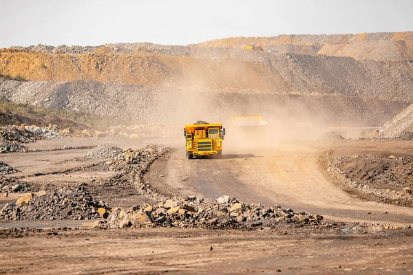 Abra la industria de minas de oro. Camión minero amarillo grande para el oro que se mueve en la carrera vial — Foto de Stock