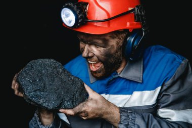 Madenci adam kömür palmiyesini tutuyor. Madencilik kavramı