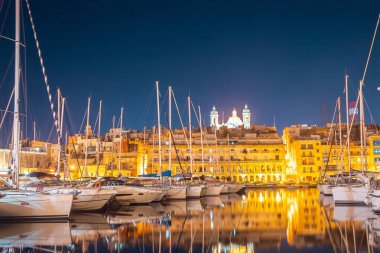 Valletta Malta Gece Manzarası 'nda tekneleri ve yatları olan bir liman. Seyahat kavramı