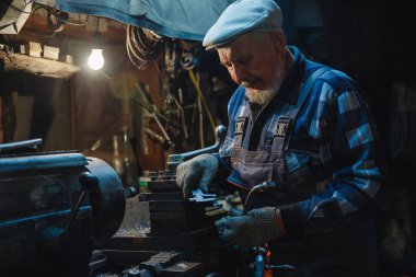 Yaşlı yaşlı erkek turner makinede metal kolları. Konsept emeklilik işçisi endüstriyel, işyeri
