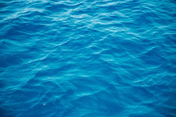 Přírodní pozadí modré moře s vlnami, azurově čistá vodní pláž. Letecký pohled shora — Stock fotografie