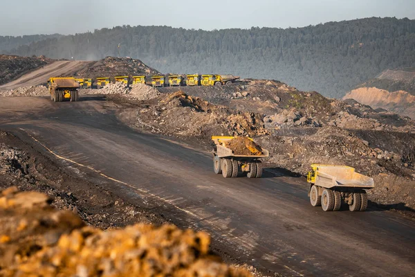 Big yellow mining truck for anthracite. Open pit mine, extractive industry for coal