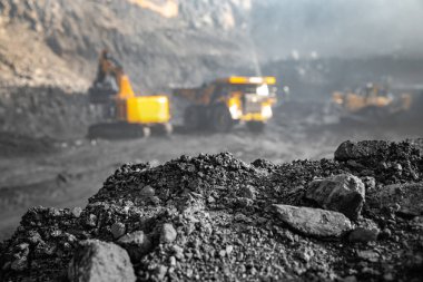 Kömür ocağı mayını. Arka planda bulanık antrasit mineralleri kazıcıyı büyük sarı kamyona yükleme