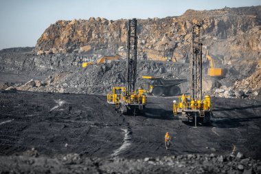 Sondaj makineleri patlayıcı yerleştirmek için sıkıcı kuyular kuruyor. Toprak patlamasından maden kömürü ve mineralleri açın