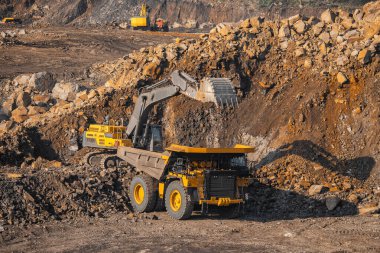 Açık maden endüstrisi, kazıcı antrasit için büyük sarı maden kamyonuna kömür yüklüyor