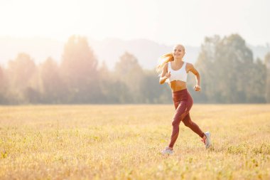 Genç sarışın fitness kadın atlet parkın koşucusu Sunrise