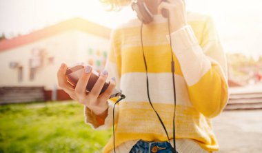 Genç kız telefondan müzik dinliyor ve internete bağlanmış kulaklıklarla sörf yapıyor. İfade özgürlüğü kavramı