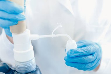 Kaliteli suyun bileşimini analiz eden kimya laboratuvarı, laboratuvar önlüklü doktor pipeti tutuyor.