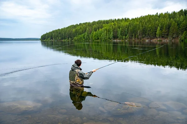 Fischer mit Rute Fliegenfischen im Fluss morgens Sonnenaufgang Spritzwasser — Stockfoto