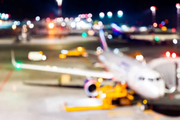 Blur av flygplan flygplats bakgrundsnatt mot ljus, väntar på passagerare — Stockfoto