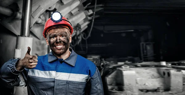 Retrato trabalhando jovem mineiro masculino em boné vermelho mostrando polegares para cima, mina de carvão excelente sinal de fundo. Conceito industrial — Fotografia de Stock