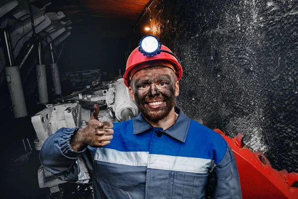 Retrato trabajando joven minero masculino en gorra roja mostrando pulgares hacia arriba, excelente signo de fondo mina de carbón. Concepto industrial — Foto de Stock