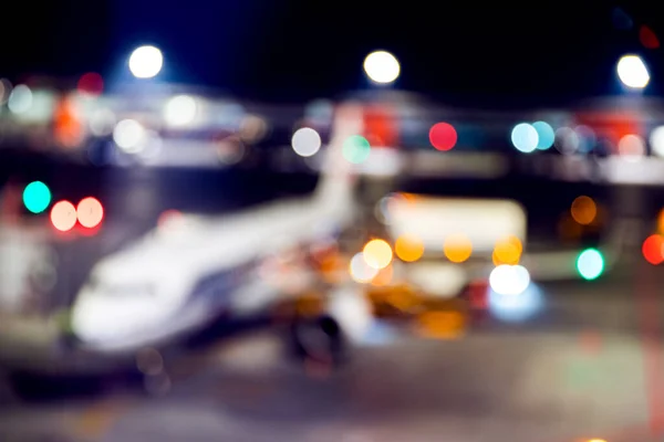 Desenfoque de la noche de fondo del aeropuerto del avión contra las luces, esperando a los pasajeros — Foto de Stock