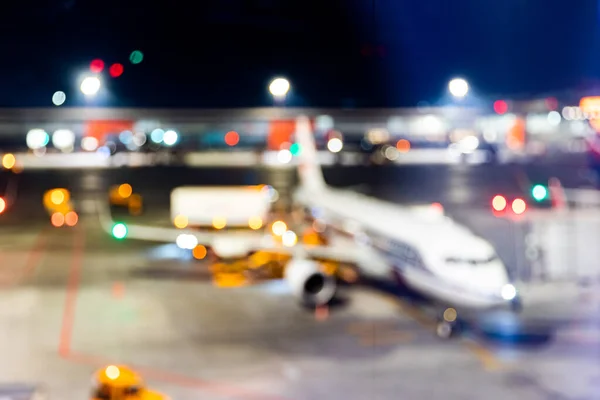 Desenfoque de la noche de fondo del aeropuerto del avión contra las luces, esperando a los pasajeros — Foto de Stock