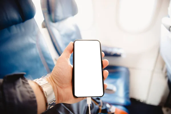 Teléfono móvil pantalla blanca en cabina de avión contra asientos de fondo y ojos de buey. Copiar espacio — Foto de Stock
