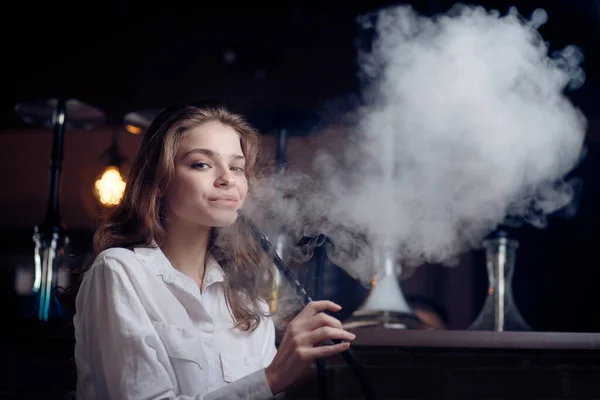 Красивая женщина курит в ночном клубе кальян или шиша-бар — стоковое фото
