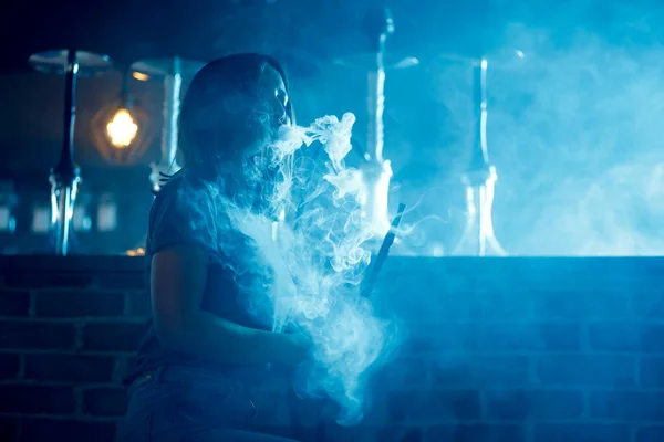 Hermosa mujer en el club nocturno de humo hookah o shisha bar, fondo azul — Foto de Stock