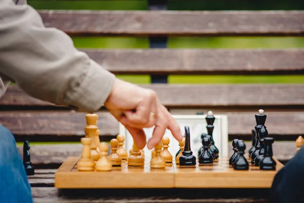 Elderly man senior holds chess piece game board outdoors — Stock Photo, Image